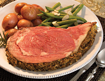 3group2 White plate filled with slice of rare prime rib. Roasted red potatoes and green beans almandine at top of plate