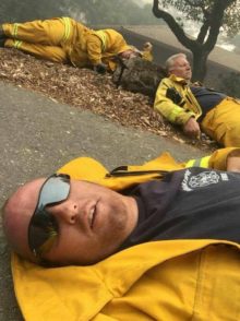 Tired Firefighters_preview 3 male firefighters in yellow protective clothing, laying on ground, exhausted. Smokey air.