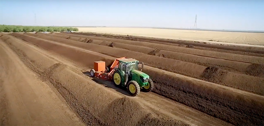 04222020f_Compost Tractor driving between rows of piled compost taken from Harris Feeding Company feedlot